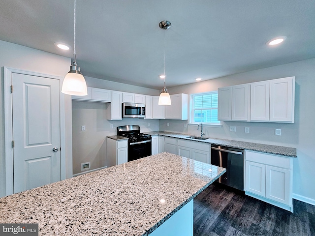 kitchen featuring hanging light fixtures, white cabinetry, dark hardwood / wood-style flooring, stainless steel appliances, and sink