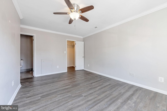 unfurnished bedroom with a walk in closet, ceiling fan, hardwood / wood-style flooring, ornamental molding, and a closet