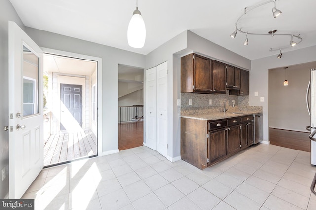 kitchen featuring backsplash, dark brown cabinets, pendant lighting, and light wood-type flooring