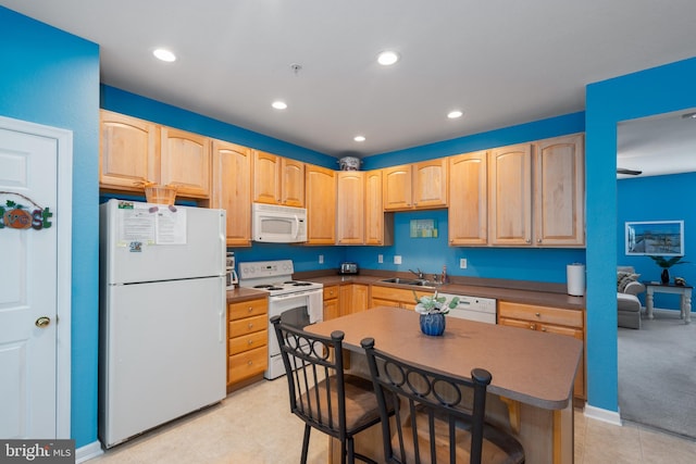 kitchen featuring white appliances, light brown cabinetry, and sink