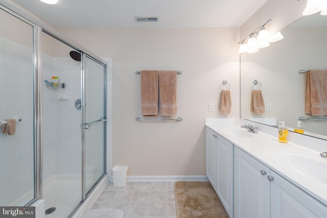 bathroom featuring tile patterned floors, a shower with shower door, and vanity