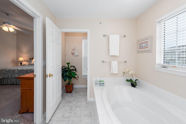 bathroom featuring ceiling fan and tiled bath