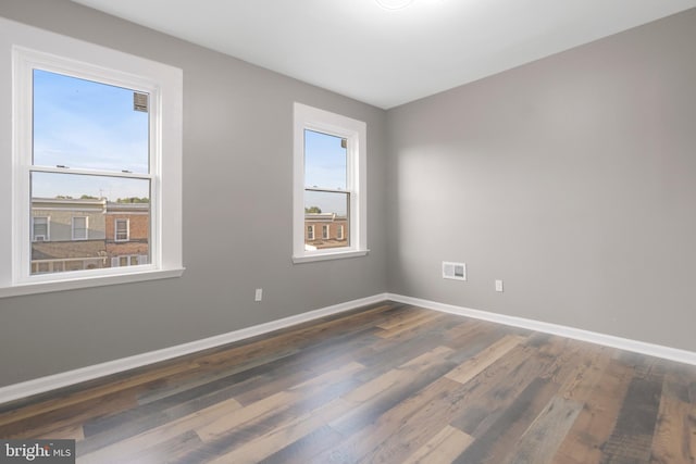 unfurnished room with dark wood-type flooring