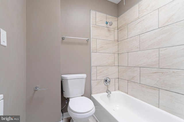 bathroom featuring tiled shower / bath and toilet