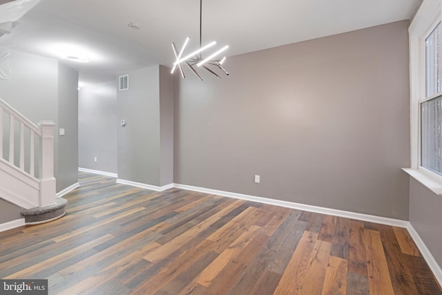 unfurnished dining area featuring an inviting chandelier and dark hardwood / wood-style floors