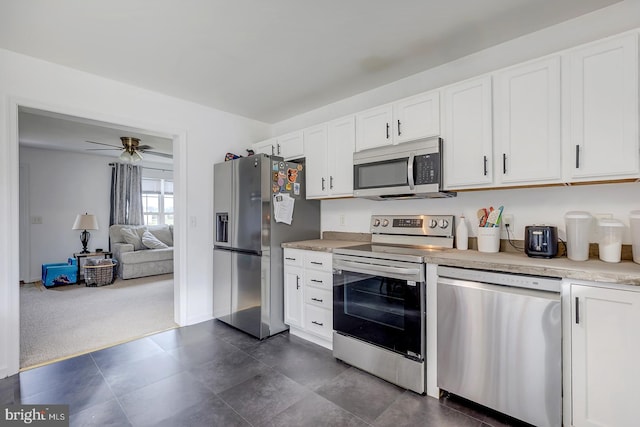 kitchen featuring white cabinets, dark colored carpet, ceiling fan, and appliances with stainless steel finishes