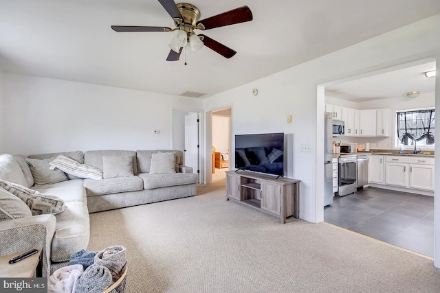 living room with dark colored carpet, ceiling fan, and sink