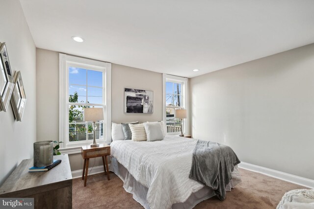 bedroom with multiple windows and carpet floors