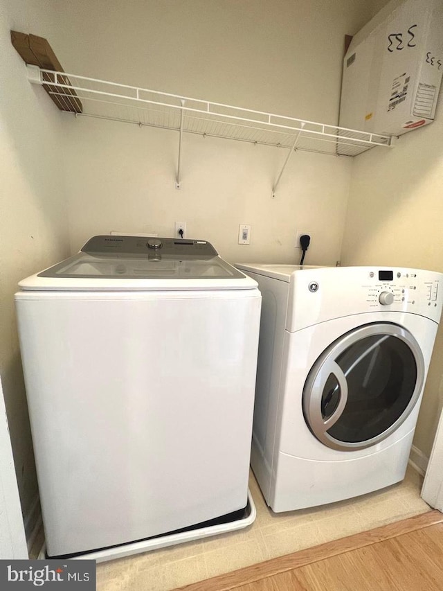 clothes washing area featuring light hardwood / wood-style floors and independent washer and dryer