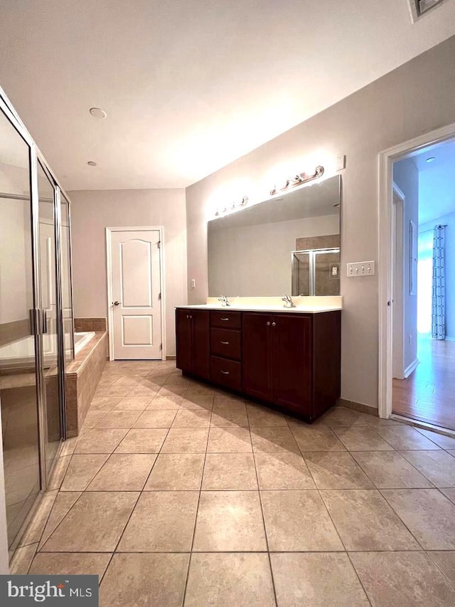 bathroom featuring vanity, shower with separate bathtub, and tile patterned flooring