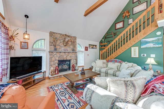 living room featuring wood-type flooring, lofted ceiling, and a fireplace