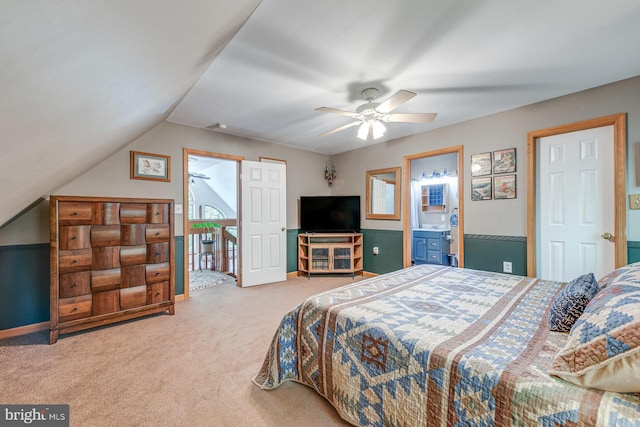 carpeted bedroom with ceiling fan, ensuite bath, and vaulted ceiling