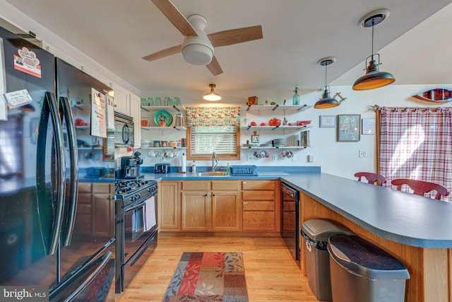 kitchen with ceiling fan, light hardwood / wood-style flooring, kitchen peninsula, and black appliances