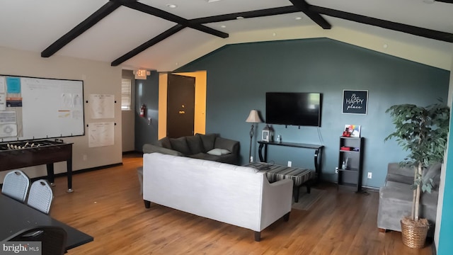 living room featuring wood-type flooring and vaulted ceiling with beams