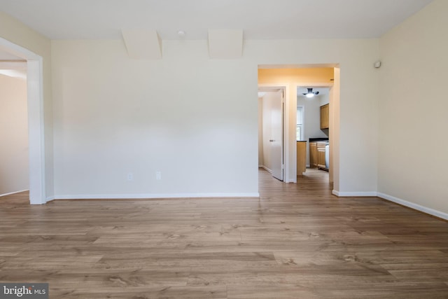 spare room featuring light wood-type flooring and baseboards