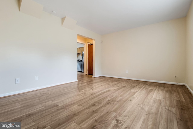 unfurnished room with light wood-style floors and baseboards