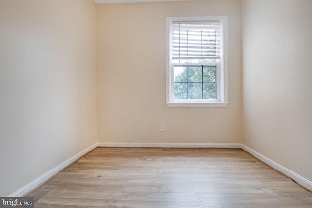empty room with baseboards and wood finished floors