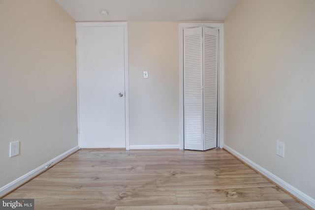 unfurnished bedroom featuring a closet, baseboards, and wood finished floors