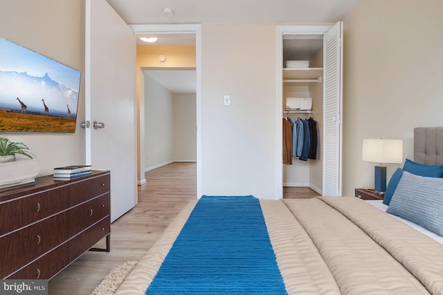 bedroom featuring a closet, baseboards, and wood finished floors