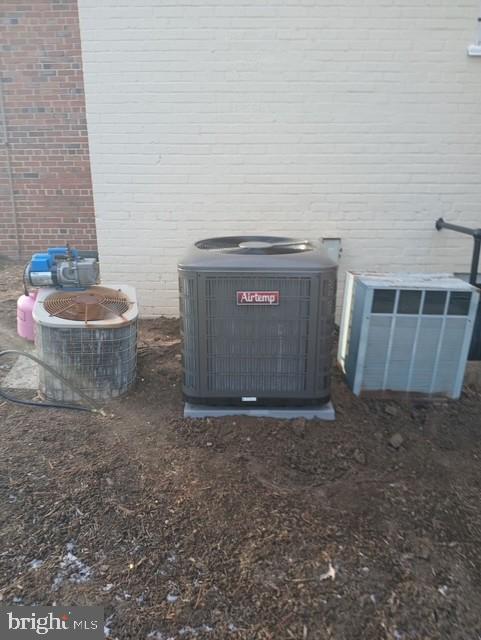 exterior details featuring central AC and brick siding