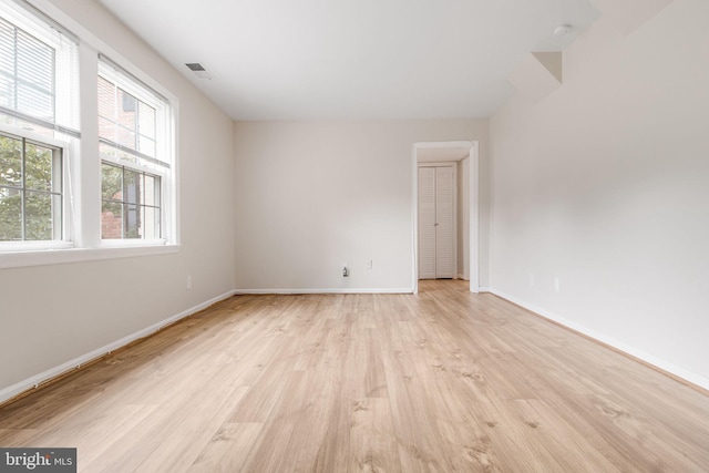spare room featuring visible vents, baseboards, and light wood-style flooring