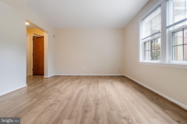 unfurnished room featuring light wood finished floors and baseboards