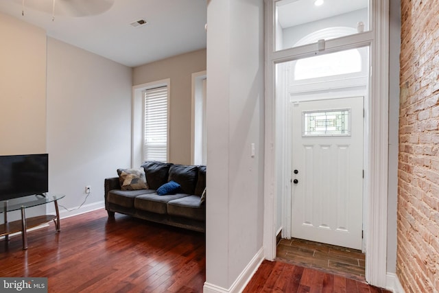 foyer entrance with ceiling fan, dark wood-type flooring, and plenty of natural light