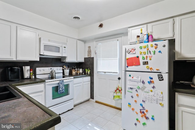 kitchen with decorative backsplash, white cabinets, white appliances, and light tile patterned floors