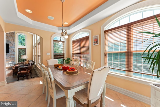 tiled dining space featuring a raised ceiling