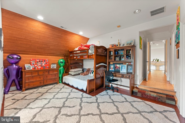 bedroom featuring wood walls and hardwood / wood-style floors