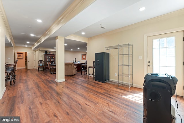 interior space featuring baseboards, crown molding, wood finished floors, and recessed lighting