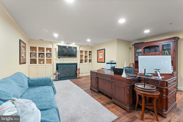 office space featuring a fireplace with flush hearth, dark wood-style floors, recessed lighting, and crown molding