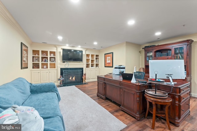 office featuring built in shelves, dark hardwood / wood-style floors, and crown molding