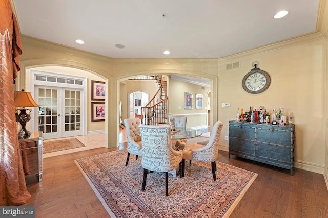 dining area featuring french doors, dark hardwood / wood-style floors, and crown molding