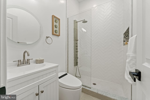 bathroom featuring a tile shower, toilet, and vanity