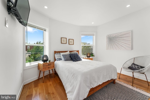 bedroom with light wood-type flooring and multiple windows