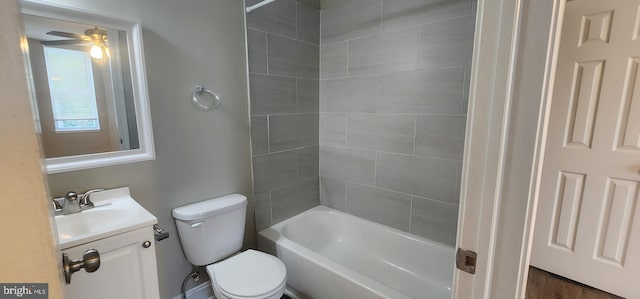 full bathroom with vanity, tiled shower / bath combo, toilet, and ceiling fan