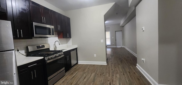 kitchen featuring appliances with stainless steel finishes, decorative backsplash, hardwood / wood-style floors, and sink