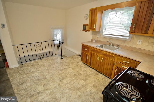 kitchen featuring black electric range oven, sink, and tasteful backsplash