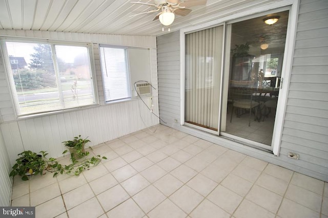 unfurnished sunroom featuring ceiling fan