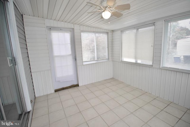 unfurnished sunroom featuring ceiling fan and a healthy amount of sunlight