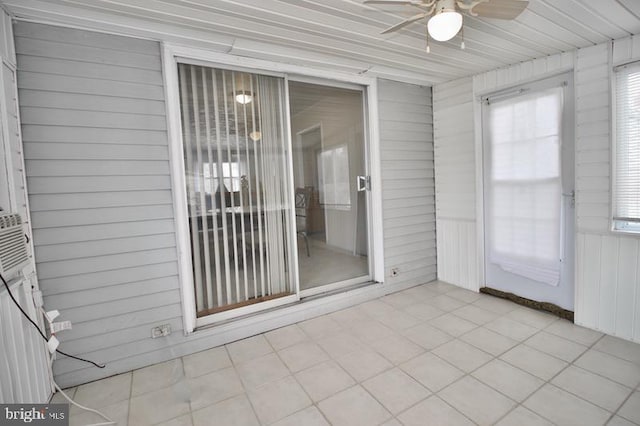 unfurnished sunroom featuring ceiling fan