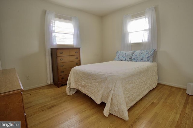 bedroom featuring light hardwood / wood-style flooring and multiple windows