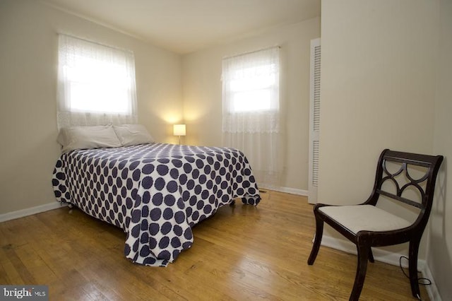 bedroom featuring multiple windows and hardwood / wood-style floors