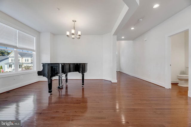 miscellaneous room with a notable chandelier and dark hardwood / wood-style flooring