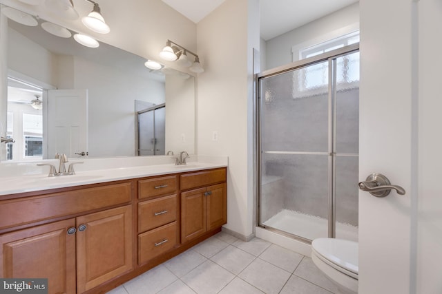 bathroom with toilet, tile patterned flooring, a shower with shower door, vanity, and ceiling fan