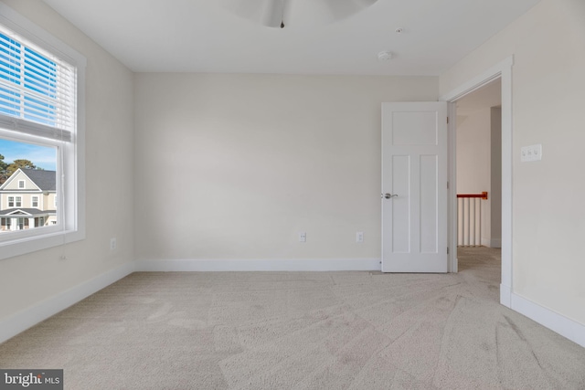 unfurnished room featuring light colored carpet