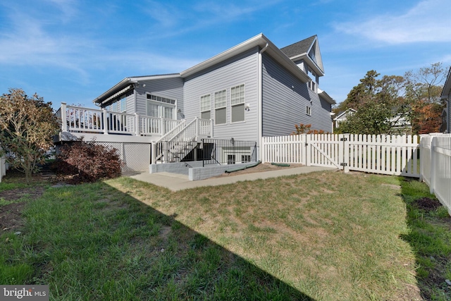 rear view of house with a yard and a deck