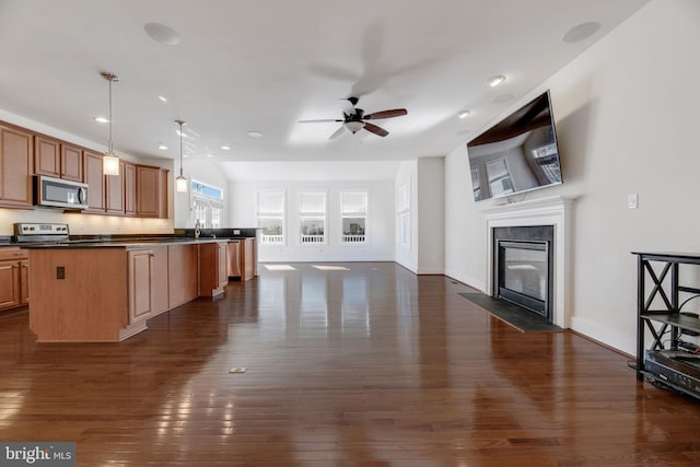 kitchen with ceiling fan, a kitchen island, pendant lighting, and dark hardwood / wood-style flooring