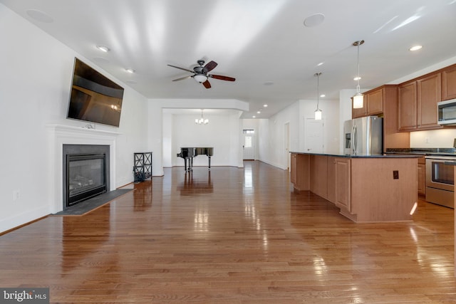 kitchen with light hardwood / wood-style flooring, a center island, stainless steel appliances, and hanging light fixtures